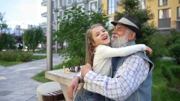 Lovely Exited Little Girl Hugging Her Caring Senior Grandpa Outdoor — Stock video