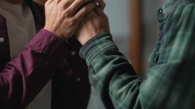 Sevgili erkek partneri tarafından nazikçe öpülen erkek ellerinin otantik yakın çekimi. Eşcinsel çiftin el ele tutuşup birbirlerini ısıttıkları dokunaklı anlar. GBTQ konsepti. Yüksek kalite 4K görüntü