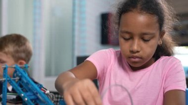 Parlak Afrikalı ilkokul öğrencisi kızın robot vinçinin robot mühendislik laboratuvarında nasıl çalıştığını dikkatle izlemesi. Fütürist teknolojiler bilim sınıfı. STEM 