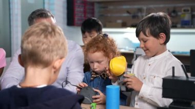 Bir grup çok ırklı öğrenci robotik mühendislik dersinde hevesli erkek öğretmenleri dinliyor. Fütürist teknolojiler bilim sınıfı. BTMM eğitim kavramı.