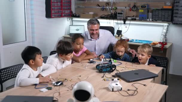 Powiększ Grupę Wielorasowych Dzieciaków Oglądających Elektryczne Samochody Mechaniczne Zajęciach Robotyki — Wideo stockowe
