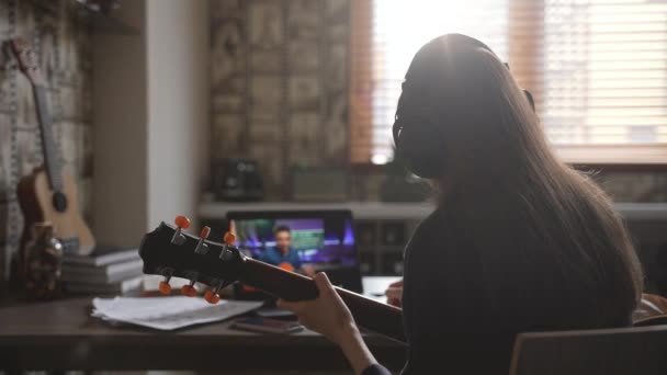 Молодой Гитарист Обучает Новым Аккордам Женщин Учащихся Видеоконференции Помещении Онлайн — стоковое видео