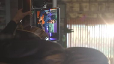Dikey çekim dikiz aynalı kadın evde uzak öğretmeniyle online müzik gitar dersi alıyor. Genç beyaz adam internet üzerinden müzik öğretiyor. Uzaktan eğitim, e-öğrenme, evde kalma konsepti 4K