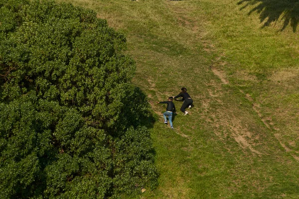Two children climbing a small mountain