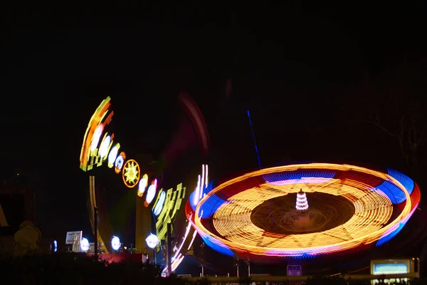 Long exposure photograph of two attractions of a tourist amusement park.
