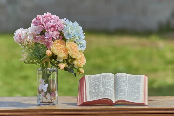 Kutsal İncil, bir buket çiçeğin yanındaki ahşap masada. Hristiyan dini kavramı