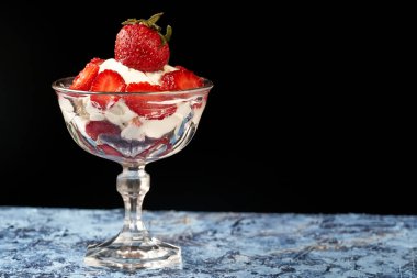 Mavi yüzeyde kremalı çilek fincanı