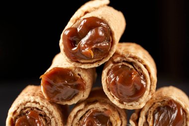 Cubanitos 'u dulce de leche ile kapatın. Kübalılar, Arjantin 'de tipik bir şekilde dondurmalı koniye benzeyen hamur silindirleridir. Şili 'de onlara cuchufli denir..