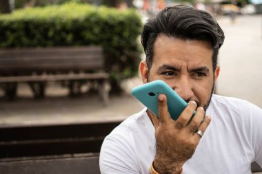 Latin adam cep telefonuna sesli mesaj kaydediyor.