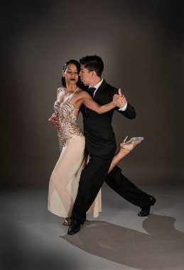 Stüdyo, Latin kadın ve Asyalı adamın tango dansını çekiyor.