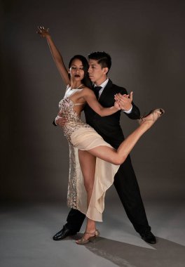 Stüdyo, Latin kadın ve Asyalı adamın tango dansını çekiyor.