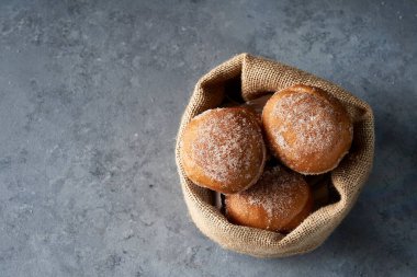Gri zeminde çuval beziyle gezen Berlinliler. Berlinliler ayrıca Berlin topları, bollo, bolinha ya da bolas de narin olarak da bilinir.