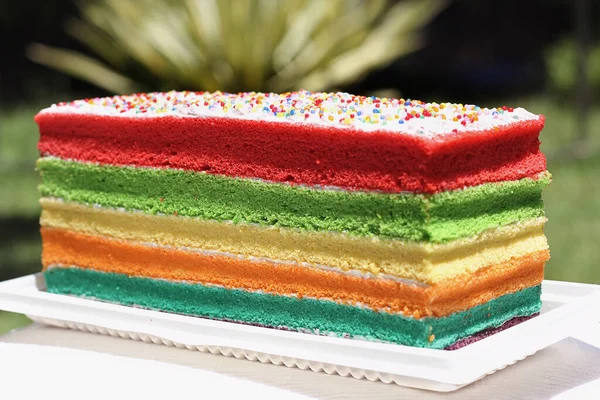 誕生の背景 白いフロスティングとストライプの虹のケーキ — ストック写真