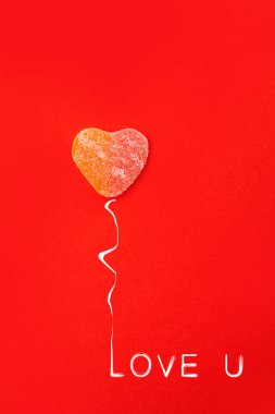 Şeker kalpler, kırmızı arka planda düz uzanın