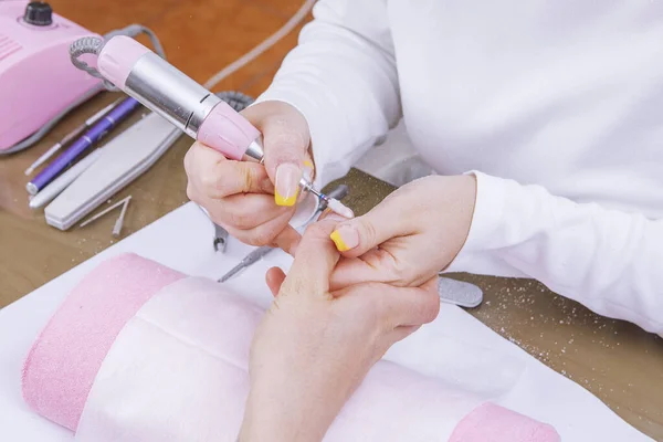 Manikiurzystka usuwa lakier do paznokci wykorzystuje elektryczną maszynę paznokcia — Zdjęcie stockowe