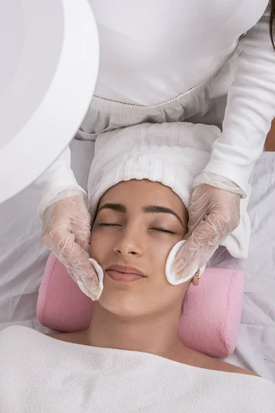 Hands of Esthetician performing facial cleansing, applying tonic with cotton pads, skin care concept, closed detail shot — Foto Stock