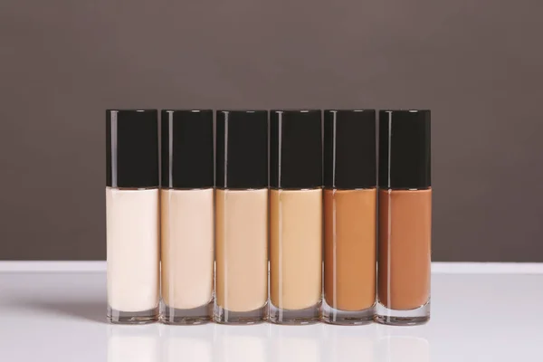 range of shades of liquid foundation in bottles isolated on background. High quality photo