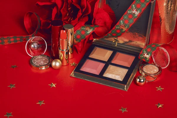 composition with makeup products and Christmas decor on red background. Christmas sale of beauty products concept. High quality photo