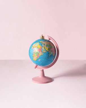 Açık pembe arka planda Xmas kadar değerli bir dünya. Minimalist Noel dekorasyonu konsepti. Yeni yıl kompozisyonu. Kış tatili fikri.