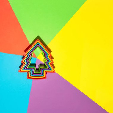 Renkli arka planda Noel ağacı. Minimalist Yeni Yıl konsepti. Yaratıcı kış tatili düz yatak fikri. Canlı Xmas pankartı.