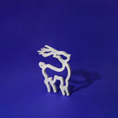 Kışın beyaz ren geyiği silueti. Minimalist Noel ve Yeni Yıl tatili konsepti. Yaratıcı Xmas tebrik kartı kompozisyonu.