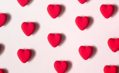 Pastel açık pembe arka planda kırmızı kalp deseni. Modern Sevgililer Günü konsepti. Yaratıcı aşk fikri.