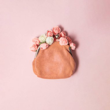Pastel açık pembe arka planda cüzdandan çiçekler çıkıyor. Yaratıcı bolluk kompozisyonu. Modern zenginlik fikri. Asgari başarı konsepti. Moda refah düzlüğü yatıyordu.