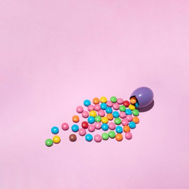 Pastel pembe arka planda şekerli Paskalya menekşe yumurtası. Renkli yaratıcı konsept.