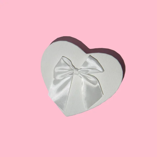 Herzförmige Schachtel Mit Weißer Schleife Auf Pastellrosa Hintergrund Minimalistische Geschenkflache — Stockfoto