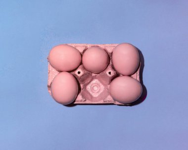 Pastel pembe yumurtalar açık mavi arka planda. Minimalist Paskalya konsepti. Yaratıcı tatil fikri. Moda yemek ilhamı.
