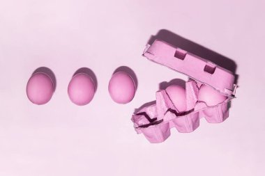 Pastel pembe yumurtalar açık arkaplanda. Yaratıcı tek renkli gıda konsepti. Asgari Paskalya kompozisyonu.