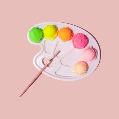Renkli pastel dondurma topları ve açık pembe arka planda boya paleti. Yaratıcı gıda konsepti. Minimalist güneşli yaz kompozisyonu.