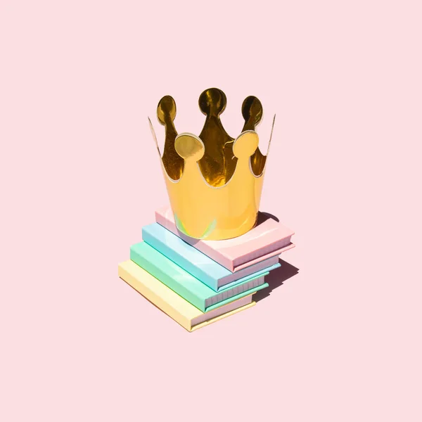 Creative academic concept. Minimal composition with books and crown on pastel light pink background. Back to school idea. Education and success inspiration.