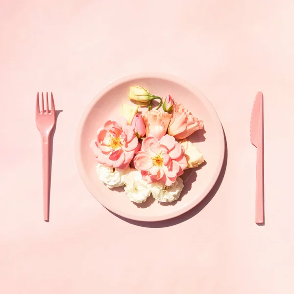 Bright pink roses and lisianthus flowers in plate on pastel background. Creative nature concept. Minimalistic summer composition. Soul food idea.