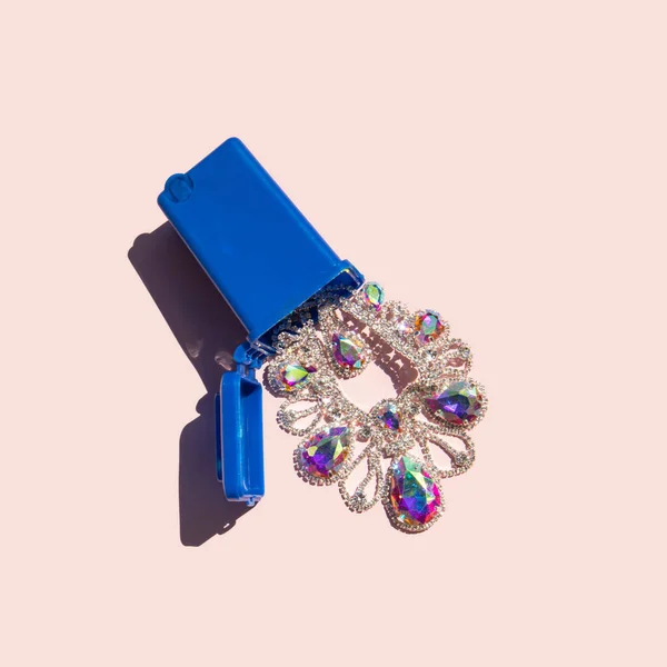 Expensive jewelry in trash bin on pastel bright pink background. Creative luxury concept. Minimalistic abundance composition.