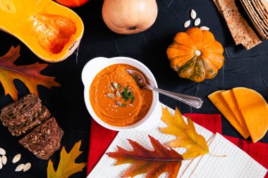 Sonbahar mevsimi sebzeleri masada. Beyaz tabakta balkabağı kremalı çorba.