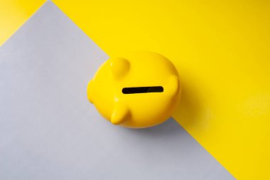 Sarı ve gri arka planda sarı domuz kumbarasının üst görüntüsü