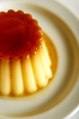 Beyaz arka planda bir tabakta vanilyalı krema.