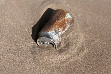 Paslı teneke kutu çöl kumunda gömülü. Çevre, geri dönüşüm, çöp konsepti