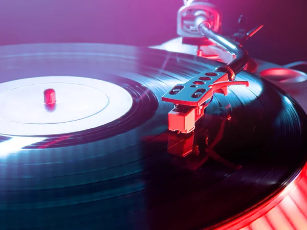 Kulüpte kırmızı ve mavi ışıklı turntable DJ.