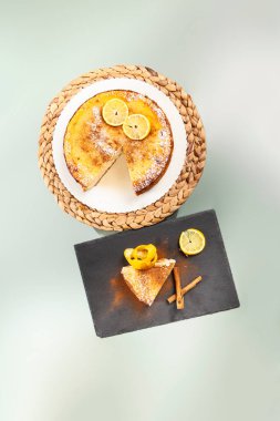 Tarçınlı limonlu cheesecake manzarası. Bir porsiyon kesilmiş, kaplanmış ve süslenmiş.