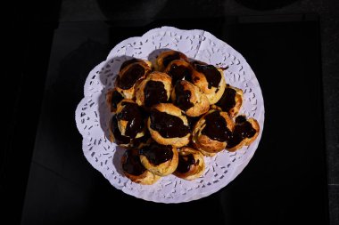 Kremalı ve çikolatalı profiterol sunumu ve kaplaması