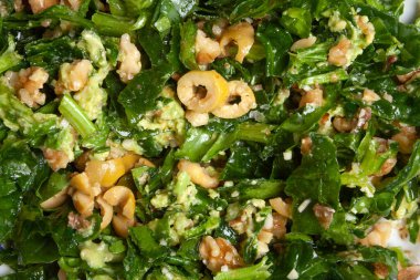 closeup and top view of homemade spinach salad with olives