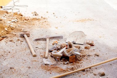 Shovel, pick, bricks and stone. Concept works and reforms.