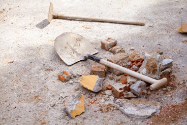 Shovel, bricks and stone. Concept works and reforms.