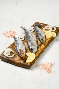 Tuzlu iwashi ringa balığı ahşap kesme tahtasına baharatla marine edilmiş.