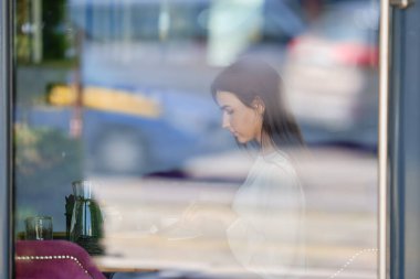 Kafenin penceresinden içeride oturan genç bayana bak.