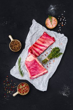 Bitkilerle ve baharatlarla ambalaj kağıdında taze çiğ kuzu pirzolası.