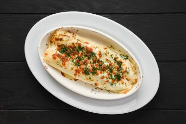 Fırında eritilmiş peynir, pastırma ve lahana ile doldurulmuş ince krep manzarası.