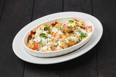 Peynirli ve sebzeli fırında pişirilmiş patates ve jambon güveci.